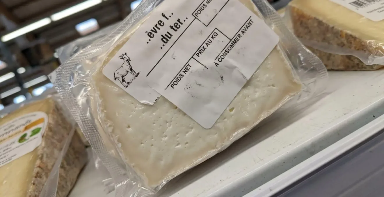 Gros plan étiquette thermique imprimée sur fromage artisanal indiquant prix, origine et date limite consommation